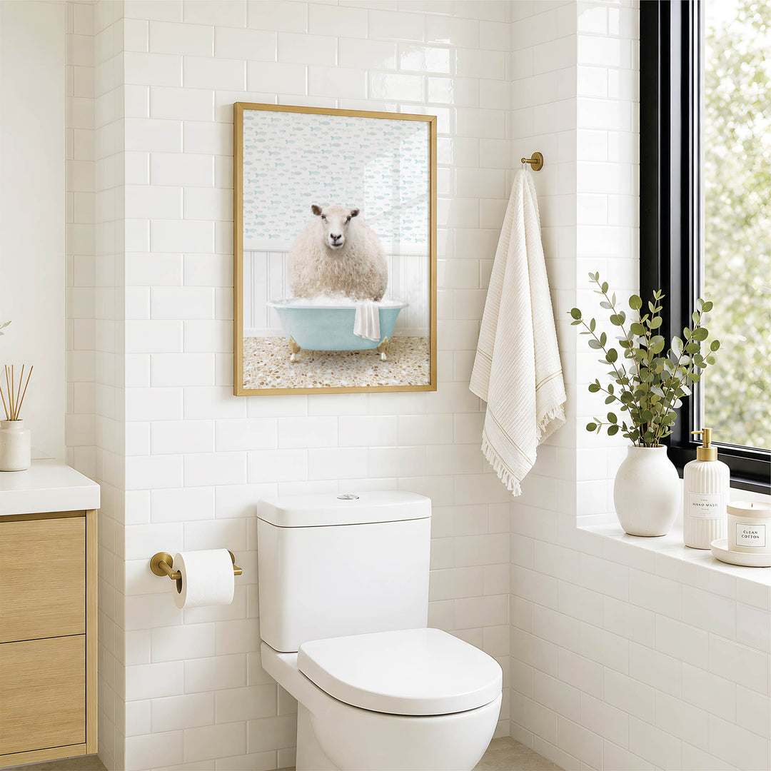 A bathroom with a white toilet, a framed picture of a sheep in a bathtub, and a window with greenery on the sill.