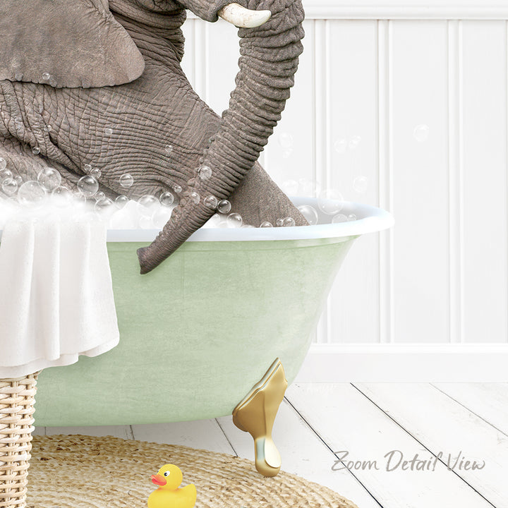 A large elephant is sitting in a green bathtub filled with bubbles, surrounded by a yellow rubber duck and a white towel.