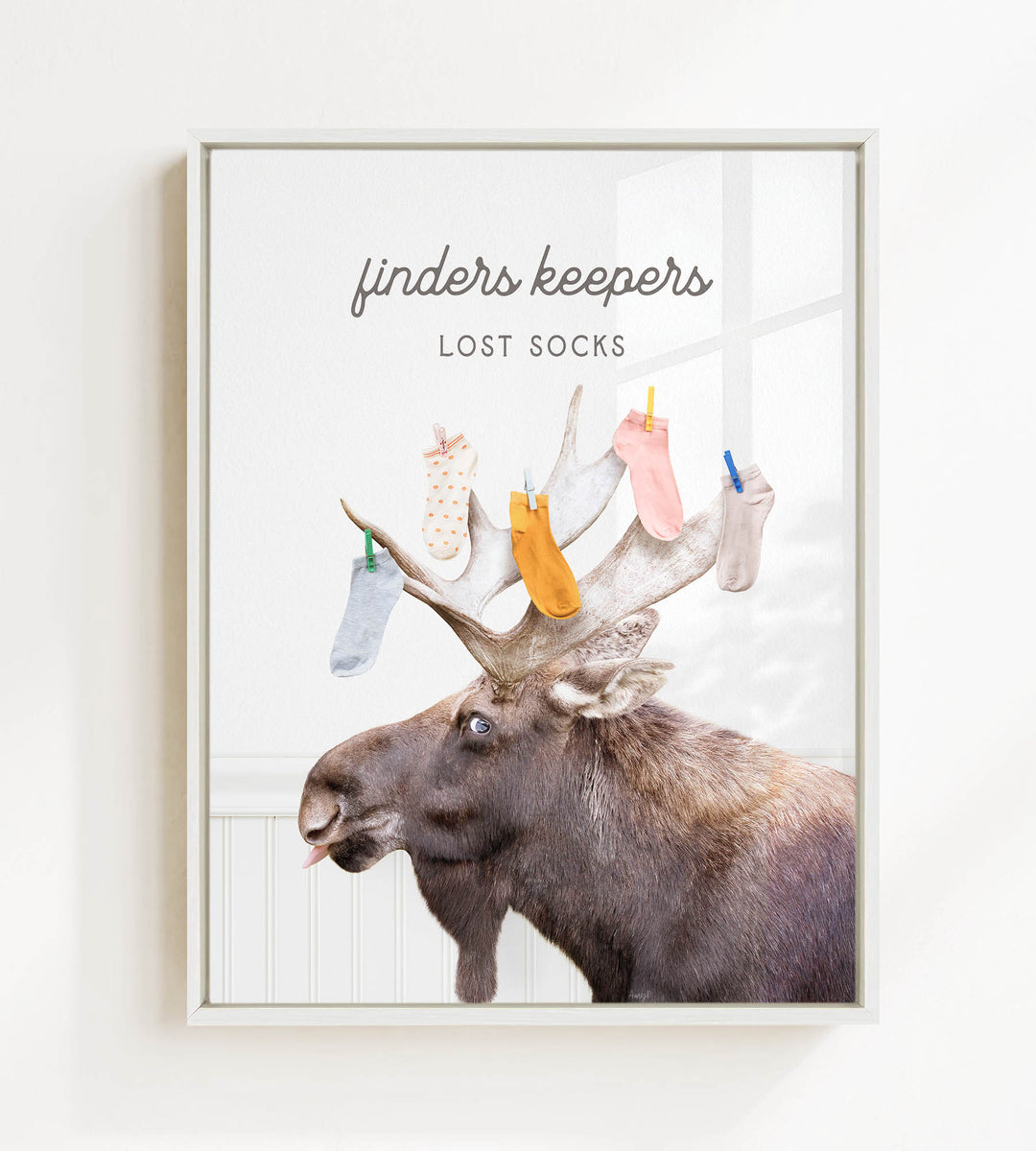 A moose with a pile of colorful socks on its head, accompanied by the text "finders keepers lost socks"