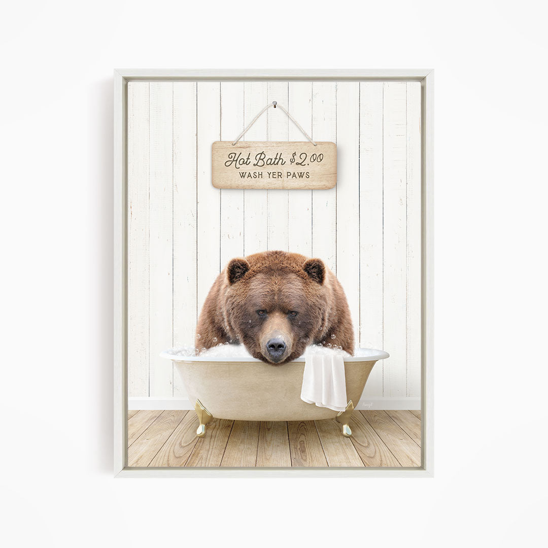 A brown bear relaxing in a bathtub, with a sign above that reads "Hot Bath $2.00 WASH YOUR Paws".