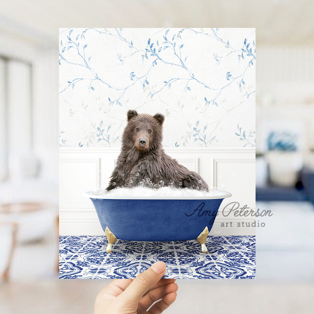 a hand holding a card with a picture of a bear in a bathtub