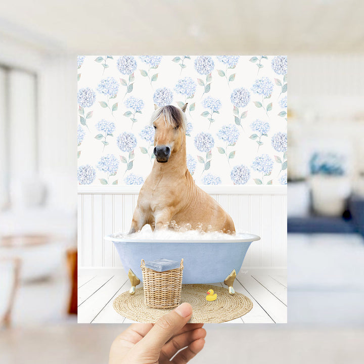 A brown horse sitting in a blue bathtub filled with water, surrounded by a wicker basket and a rubber duck.
