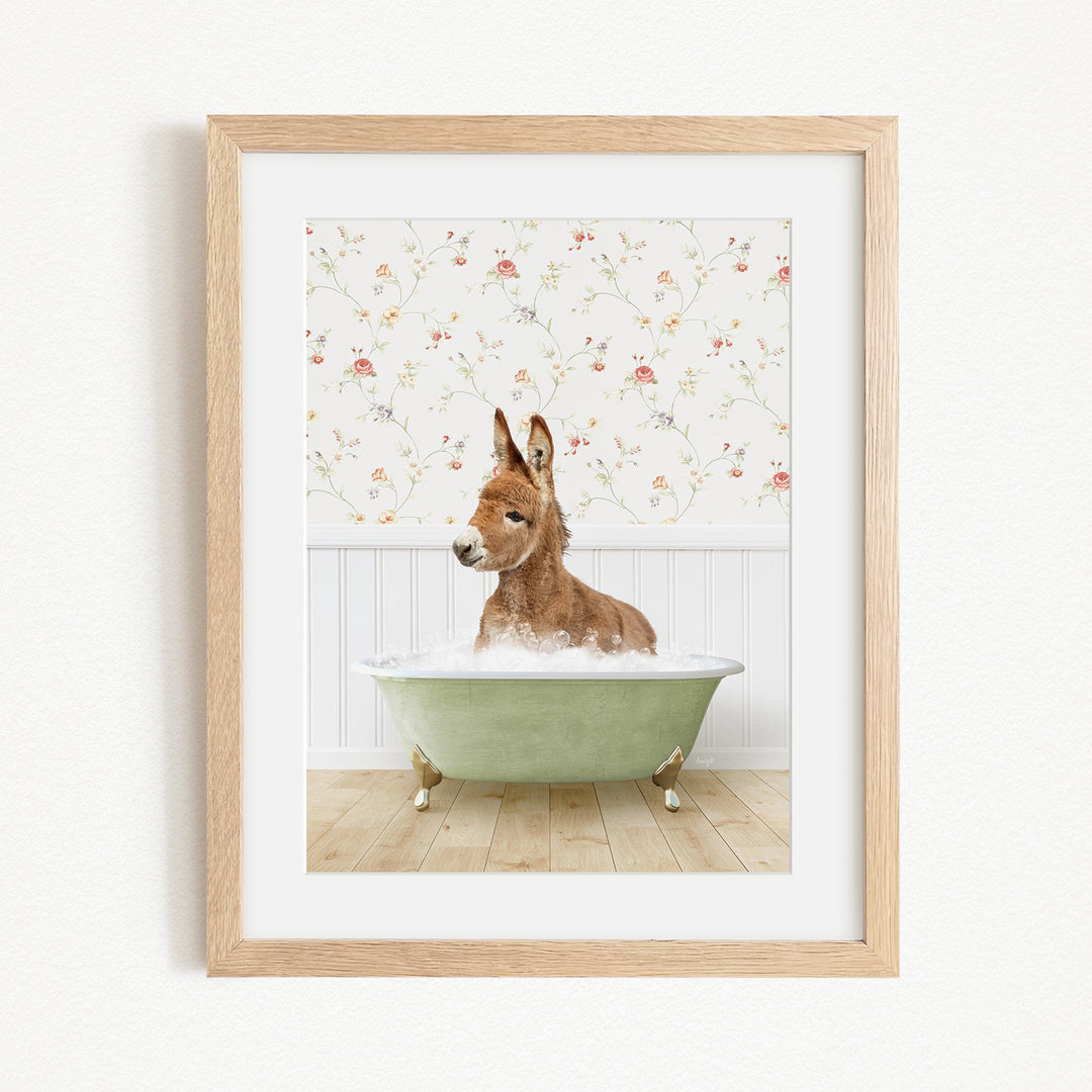 A donkey is sitting in a green bathtub filled with water, surrounded by a floral wallpaper.