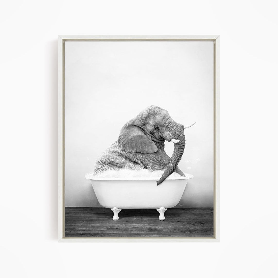 A large elephant is sitting in a white bathtub filled with water, creating a whimsical and playful scene.