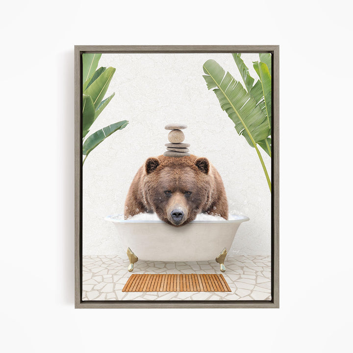 A brown bear is sitting in a bathtub filled with water, surrounded by green plants and a wooden mat on the floor.