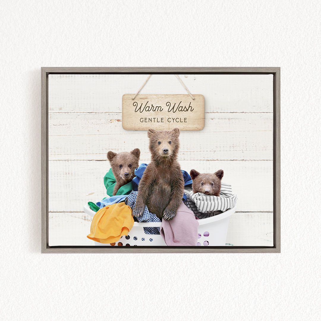 A framed image depicting three bears sitting in a laundry basket, with a sign above them that reads "Warm Wash Gentle Cycle".