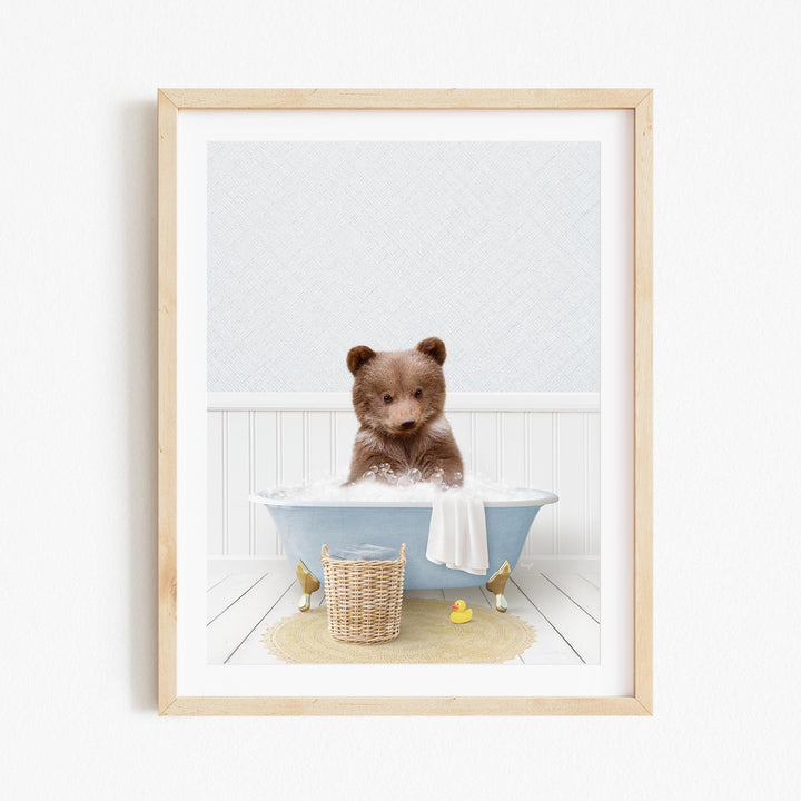 A brown bear sitting in a blue bathtub filled with water, surrounded by a yellow rubber duck and a wicker basket.
