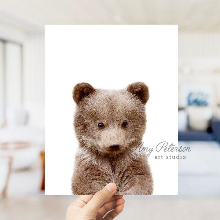 a person holding up a picture of a brown bear