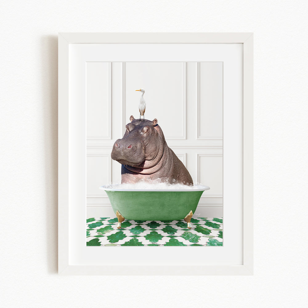 A framed image depicting a large hippopotamus sitting in a green bathtub, with a seagull perched on its head.