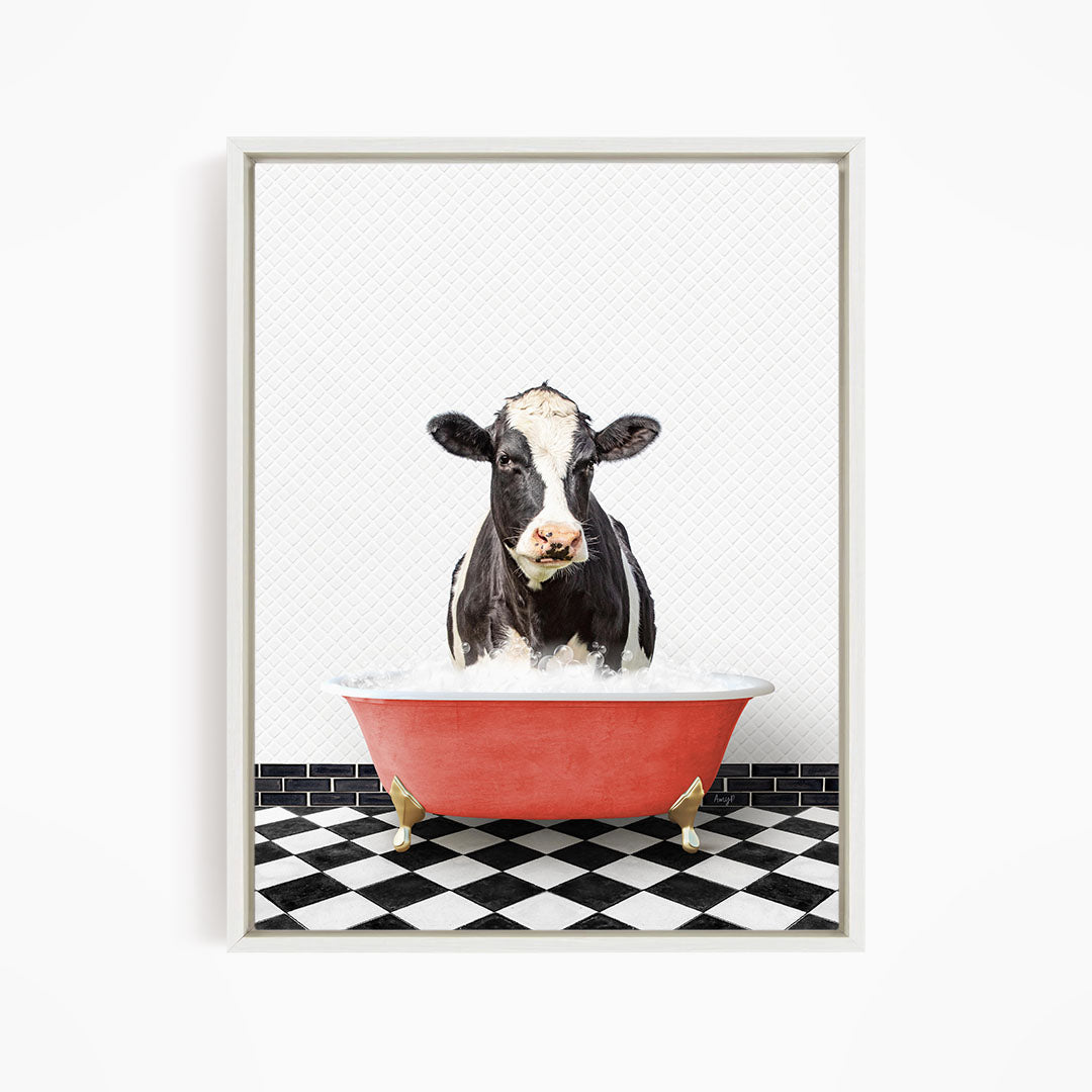 A black and white cow is standing in a red bathtub filled with water, creating a whimsical and humorous scene.