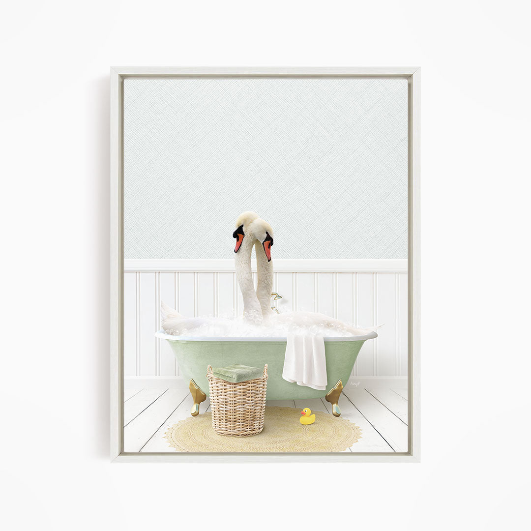 A white swan is sitting in a green bathtub filled with bubbles, with a yellow rubber duck nearby and a basket of bath toys on the floor.