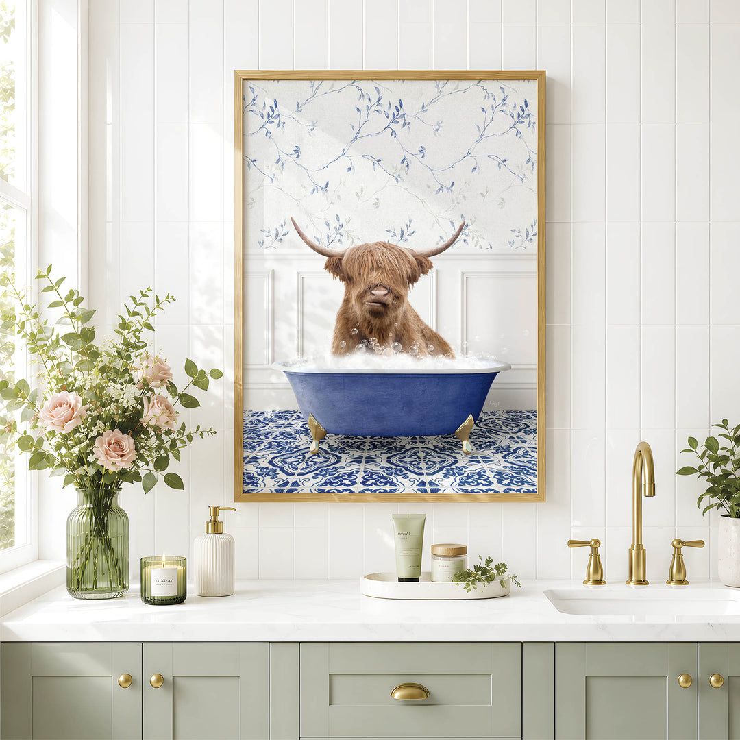 a framed picture of a Highland cow sitting in a blue bathtub, surrounded by flowers and a white and blue floral pattern on the wall.
