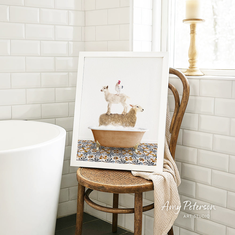 A framed image of a sheep standing on a chicken in a bathtub, placed on a wooden chair in a bathroom setting.