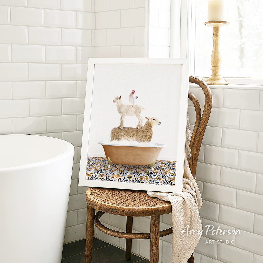 A framed image of a sheep standing on a chicken in a bathtub, placed on a wooden chair in a bathroom setting.