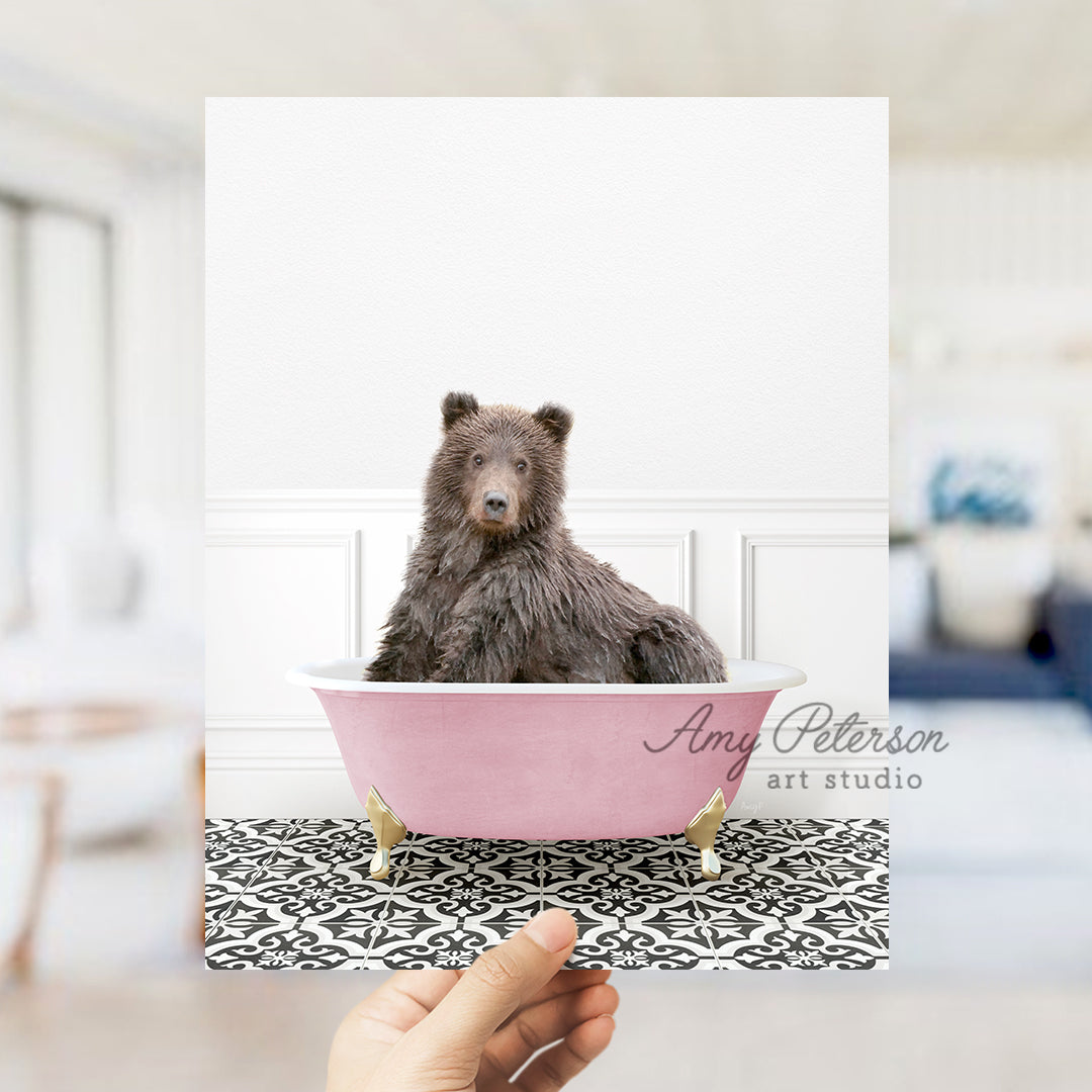 a hand holding a card with a picture of a bear in a bathtub