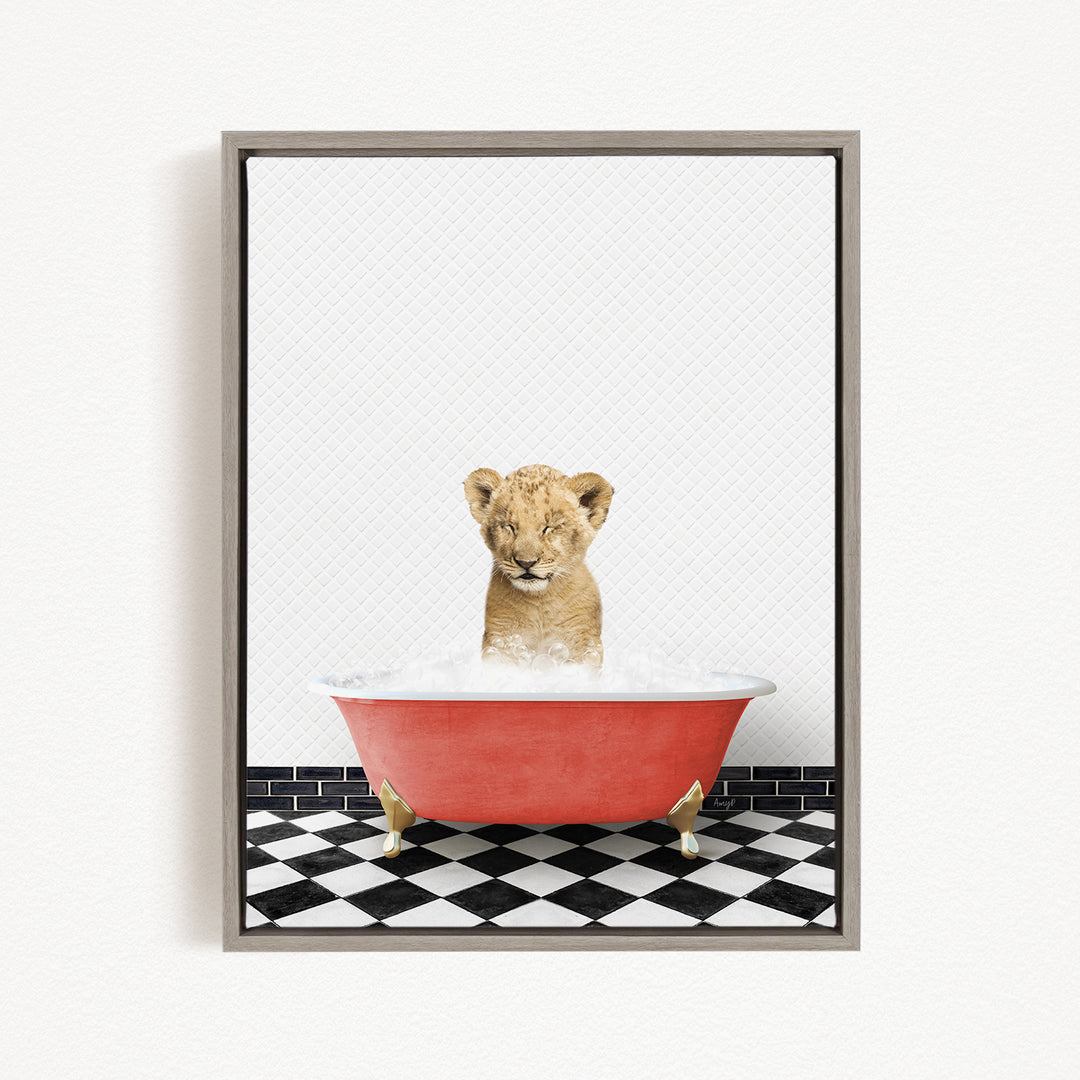 A young lion cub sitting in a red bathtub filled with water, surrounded by a black and white checkered floor.