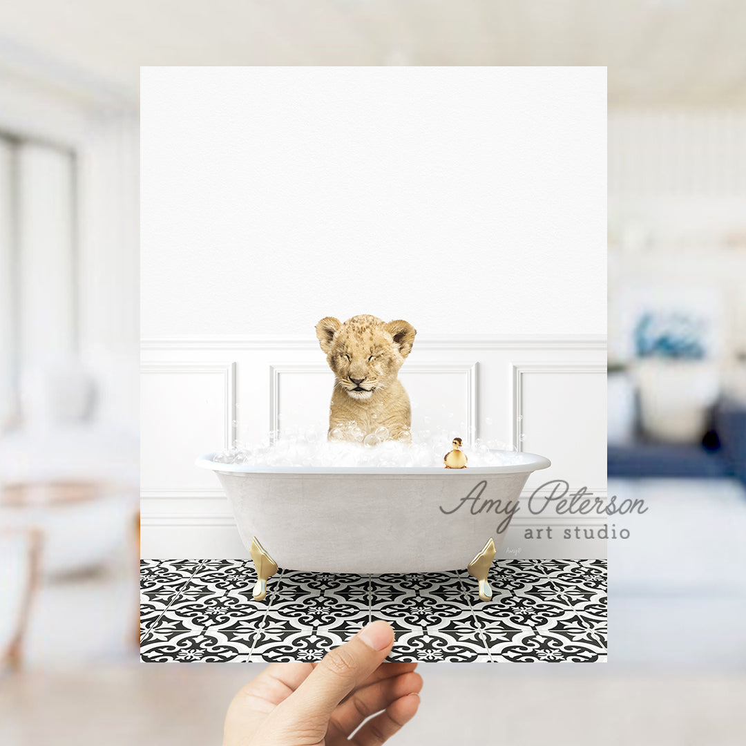 a hand holding a card with a picture of a baby lion in a bathtub