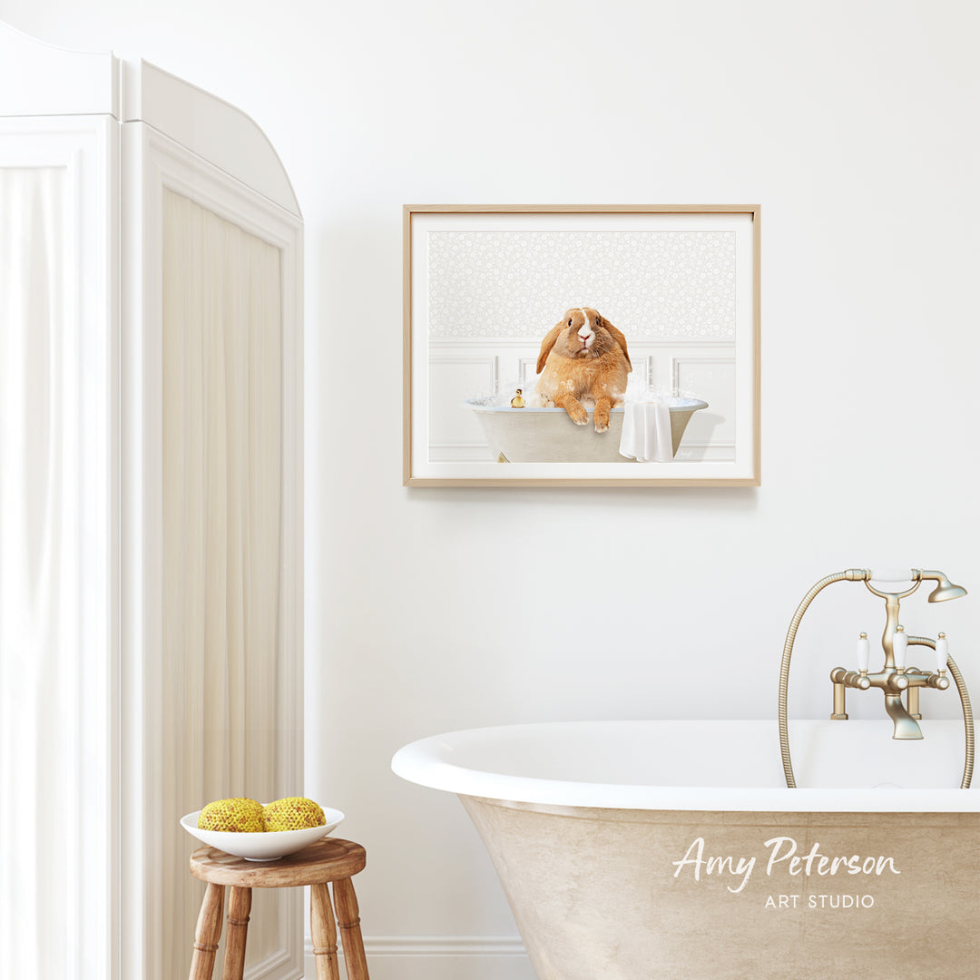 A framed image of a dog sitting in a bathtub is displayed on the wall above a white bathtub in a bathroom.