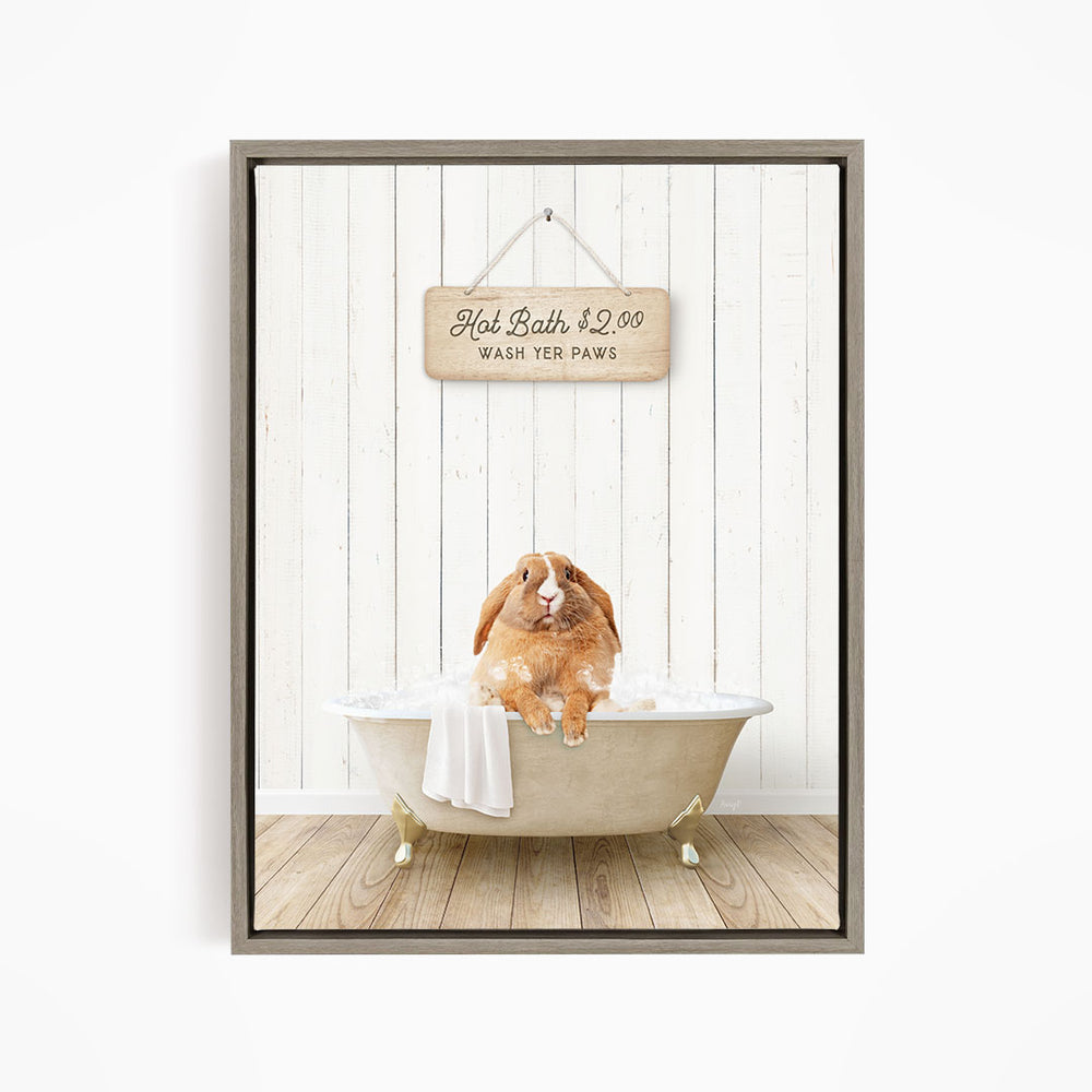A wooden sign with the text "Hot Bath $2.00 WASH YOUR Paws" hangs on a white wooden wall, with a beige bathtub containing a brown rabbit sitting in it.