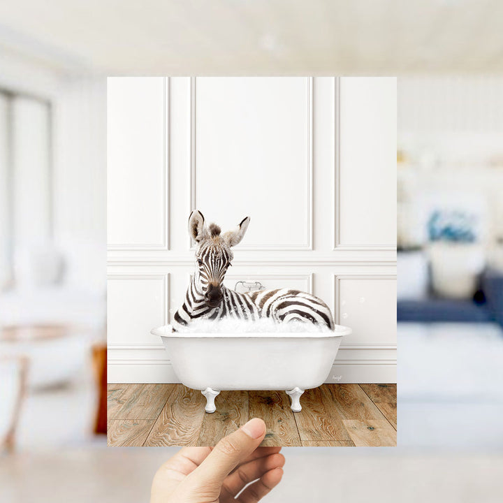 A zebra lying in a white bathtub, surrounded by a blurred background of a living room setting.