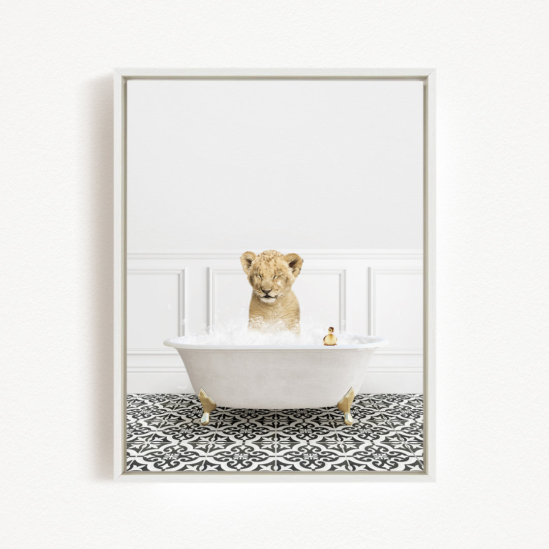 A young lion cub is sitting in a white bathtub filled with bubbles, surrounded by a black and white patterned floor.
