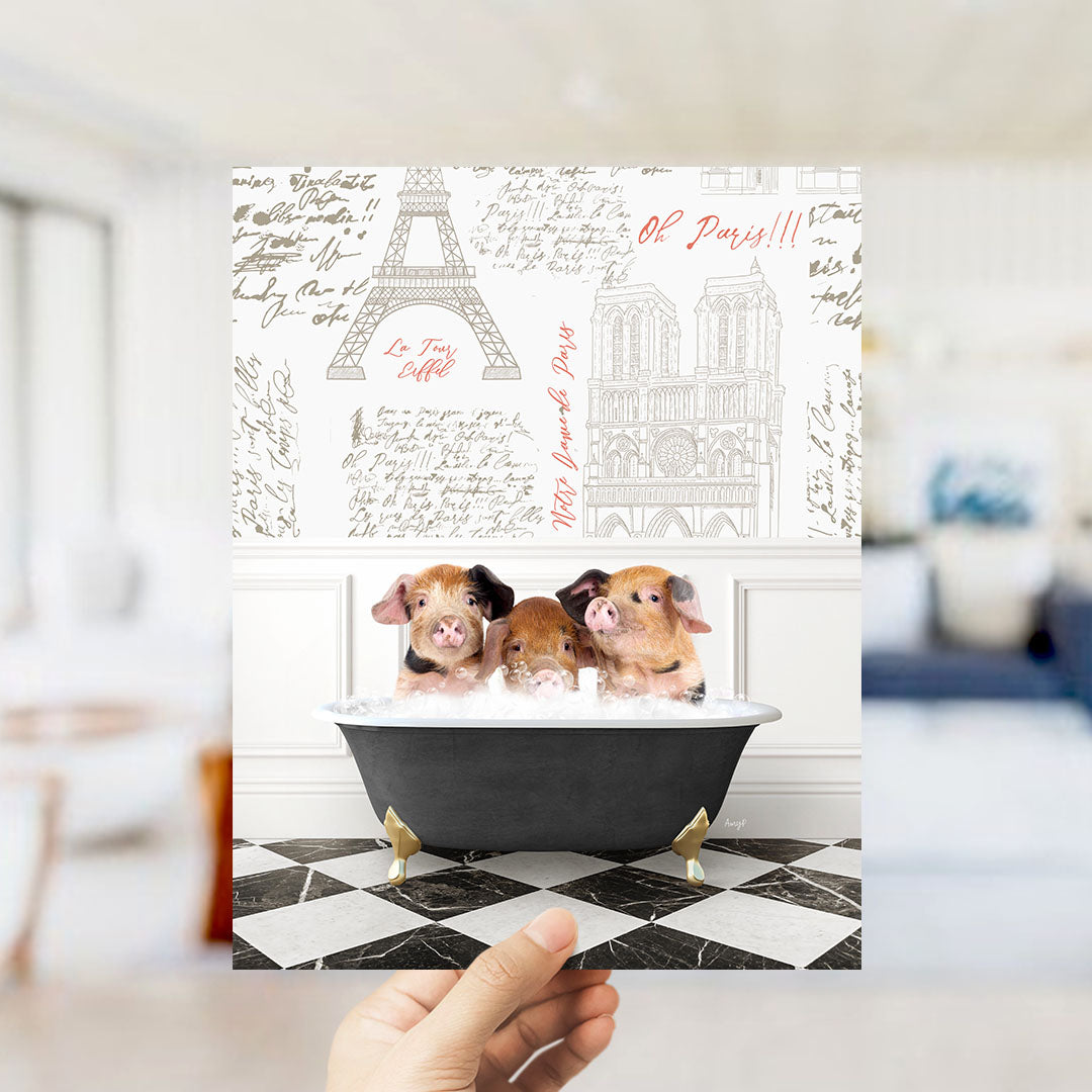 A hand is holding up a collage of images featuring three pigs sitting in a bathtub, with the Eiffel Tower and other Parisian landmarks visible in the background.