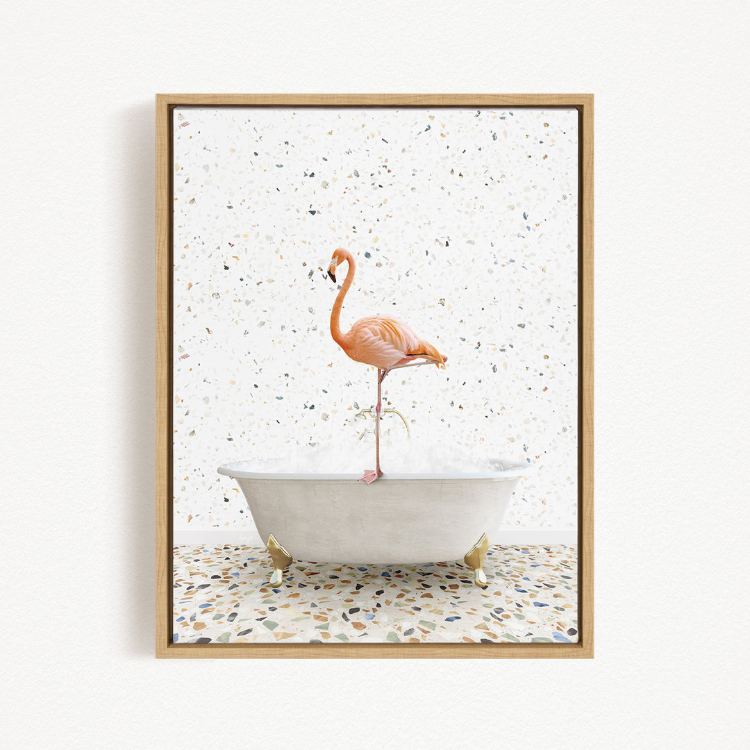 A framed image depicting a pink flamingo standing on the edge of a white bathtub filled with water, set against a speckled white background.