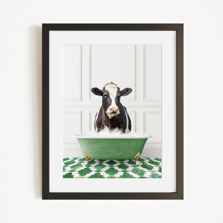 A black and white cow is sitting in a green bathtub filled with water, creating a whimsical and humorous scene.