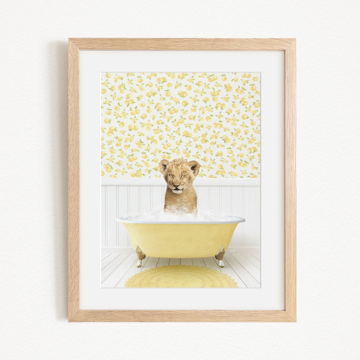 A young lion cub sitting in a yellow bathtub filled with water, surrounded by a yellow floral pattern on the wall behind it.