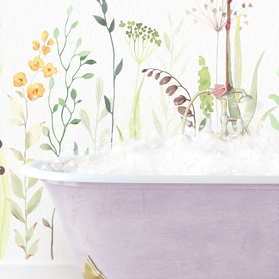 a bathtub filled with foam next to a wall with flowers