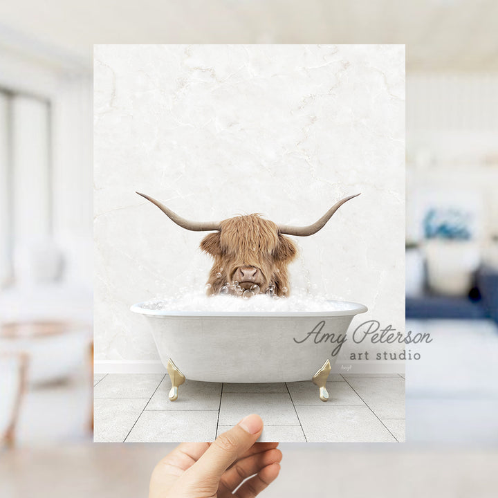 a hand holding up a photo of a bull in a bathtub