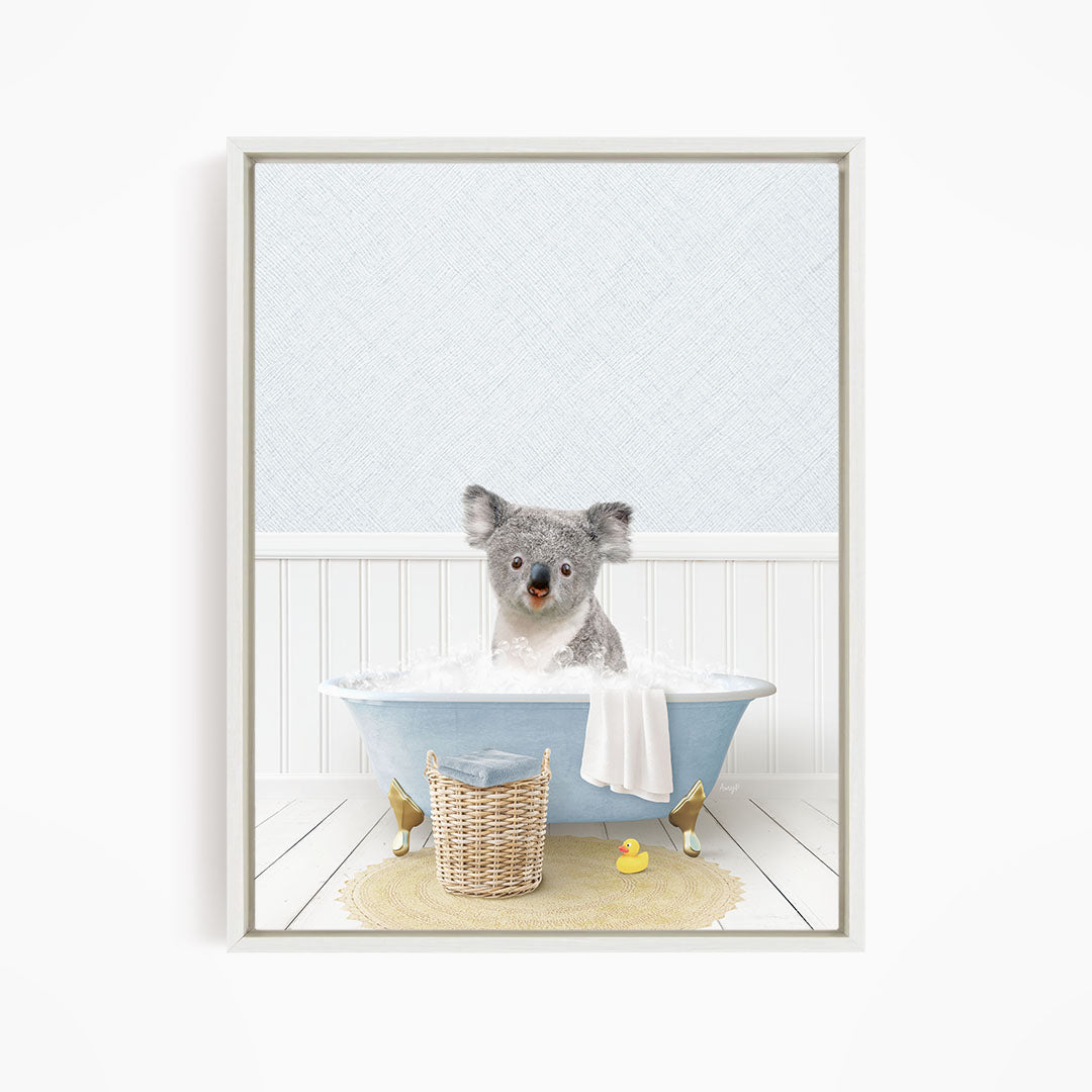 A koala bear sitting in a blue bathtub filled with water, surrounded by a yellow rubber duck and a wicker basket.