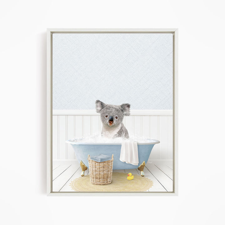 A koala bear sitting in a blue bathtub filled with water, surrounded by a yellow rubber duck and a wicker basket.
