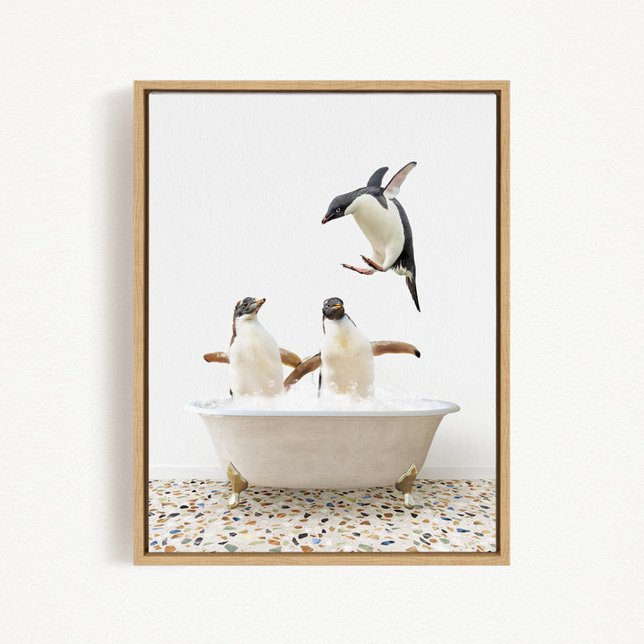 A framed image depicting three penguins in a bathtub, with one penguin flying above the tub.