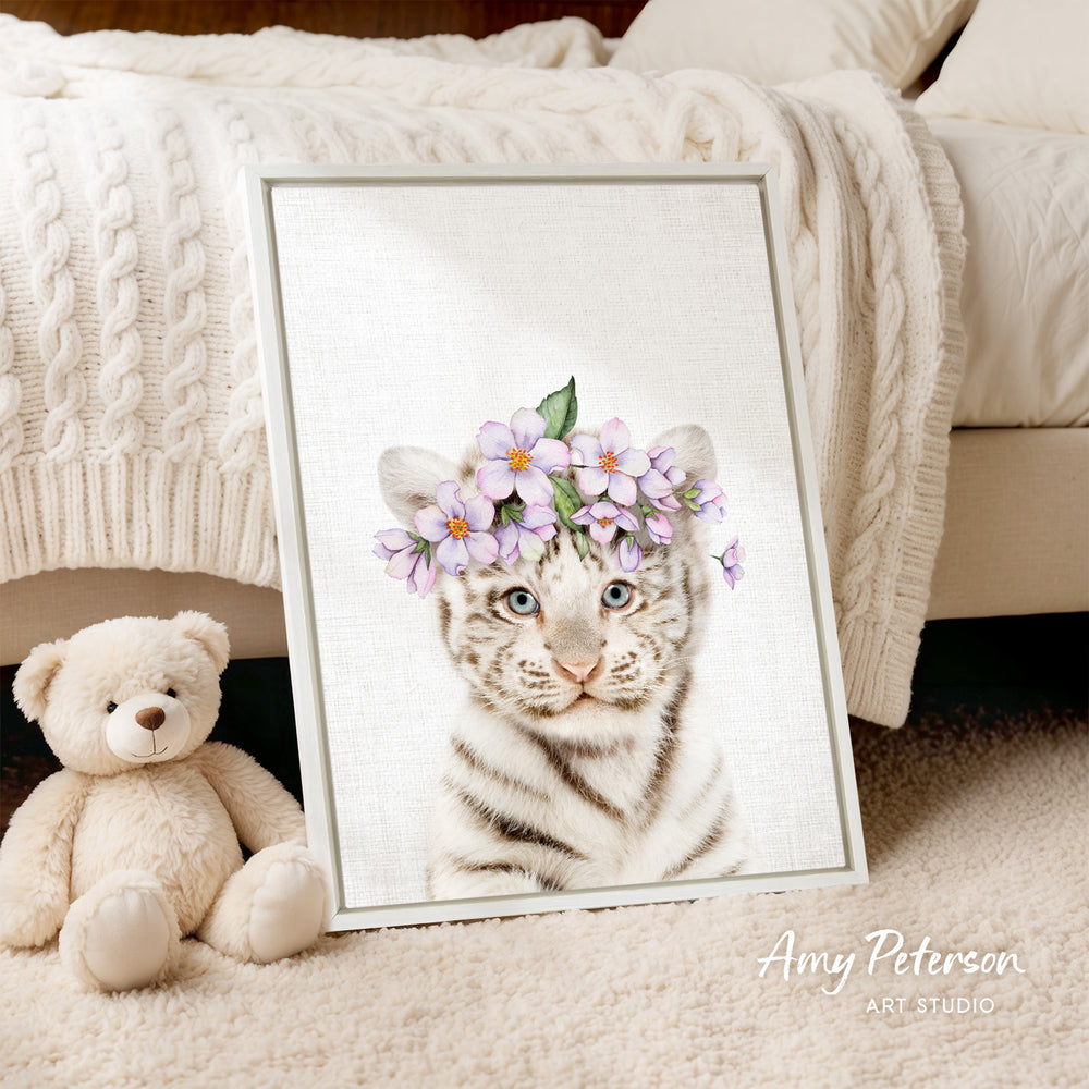 A framed print of a tiger wearing a flower crown is displayed on a beige carpet, accompanied by a teddy bear.
