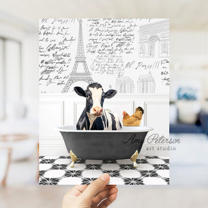 a person holding up a card with a picture of a cow in a bathtub