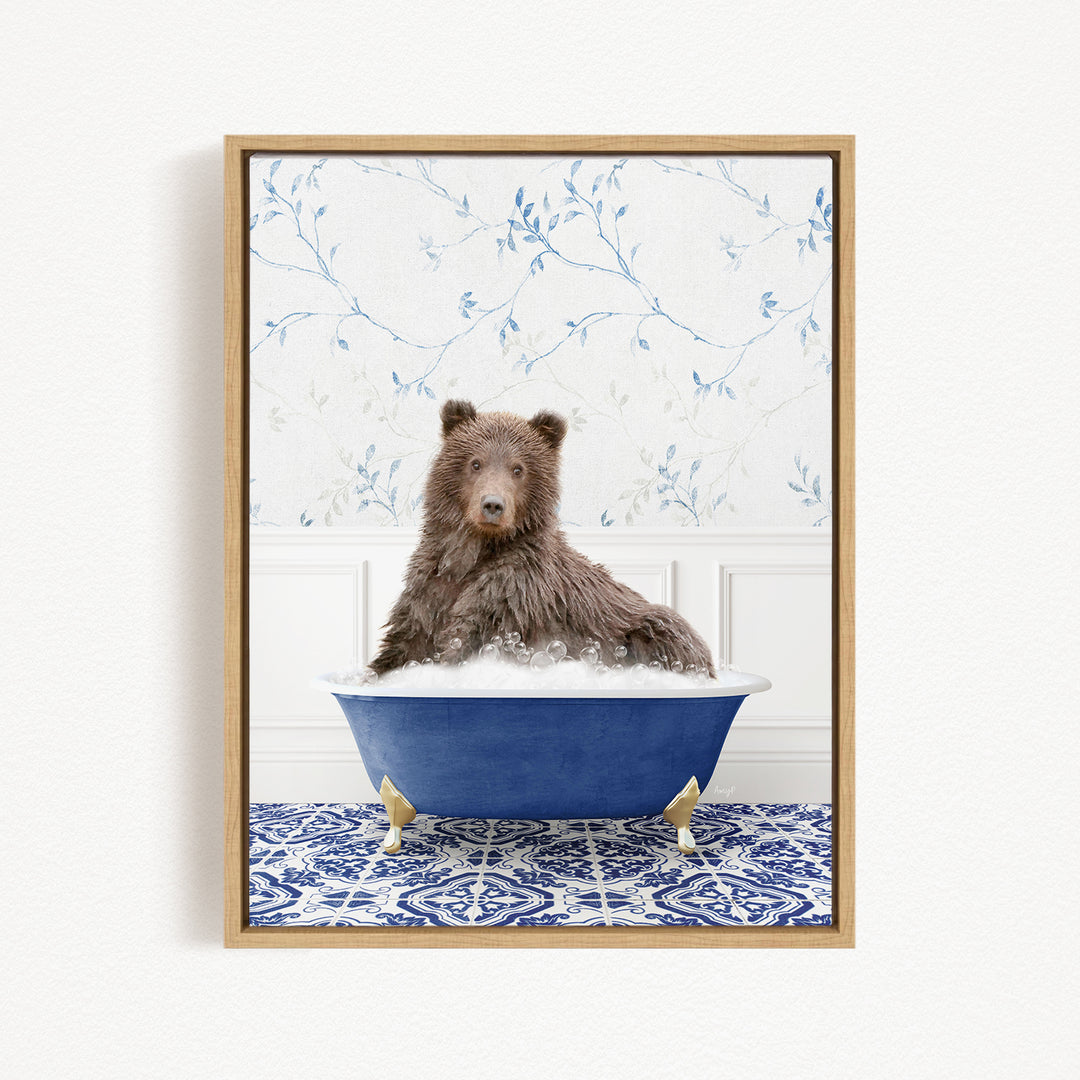 A brown bear sitting in a blue bathtub filled with bubbles, surrounded by a blue and white patterned rug and a floral wallpaper.