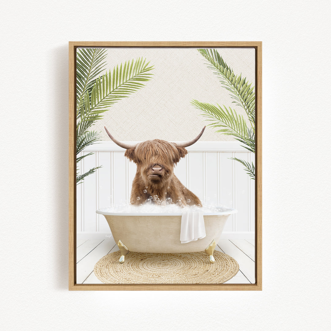 A brown cow with long horns is sitting in a white bathtub filled with bubbles, surrounded by green palm leaves.