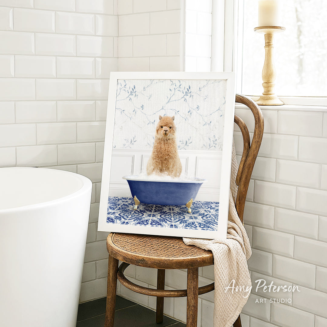 A framed image of a small dog sitting in a blue bathtub, surrounded by a white floral patterned wall and a wooden chair.