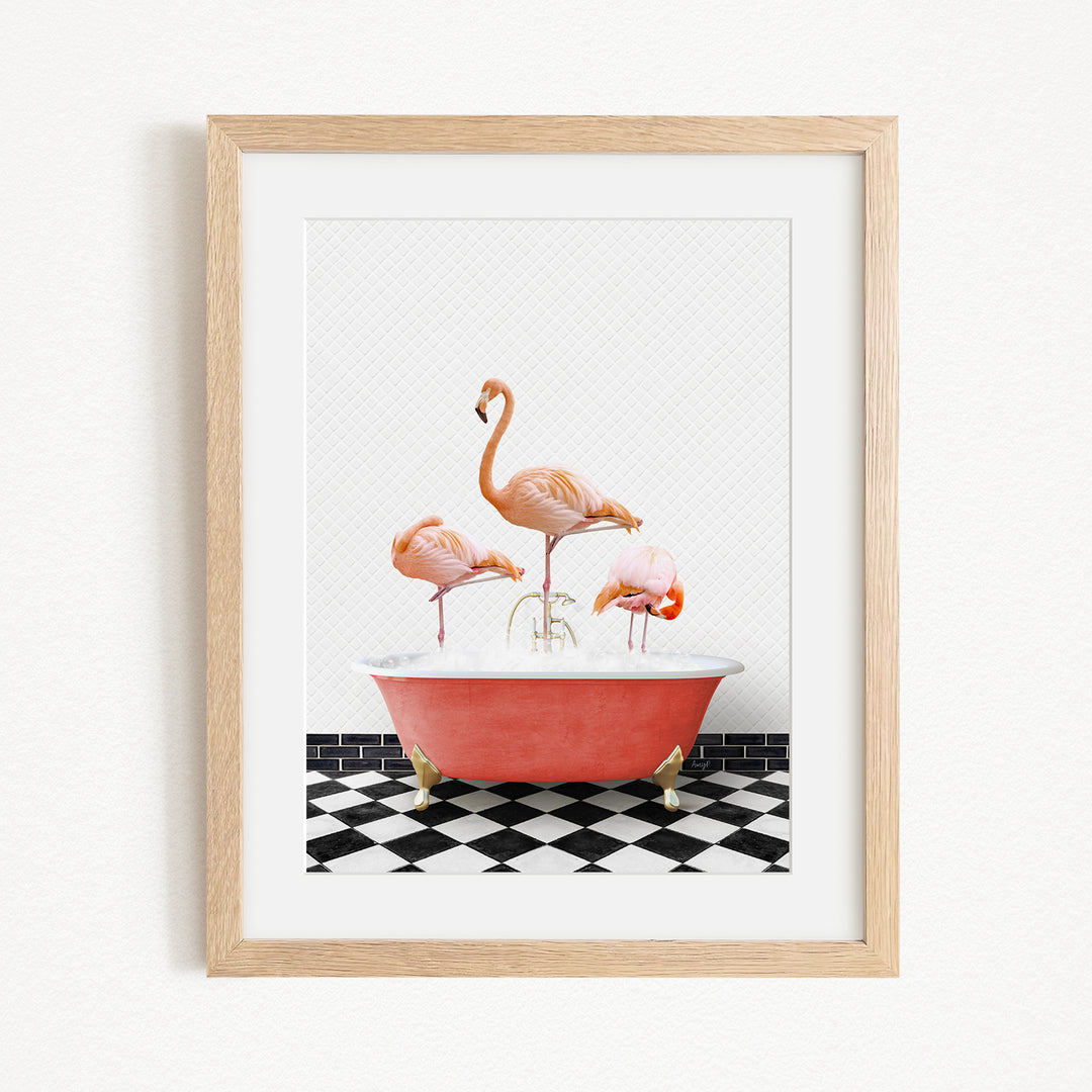 A framed image depicting three flamingos standing in a red bathtub on a black and white checkered floor.