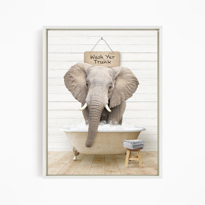 A gray elephant standing in a bathtub filled with water, with a sign above it that says "Wash Yer Trunk".