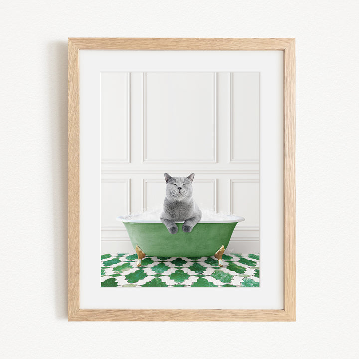 A gray cat sitting in a green bathtub filled with water, with a patterned green and white rug on the floor.