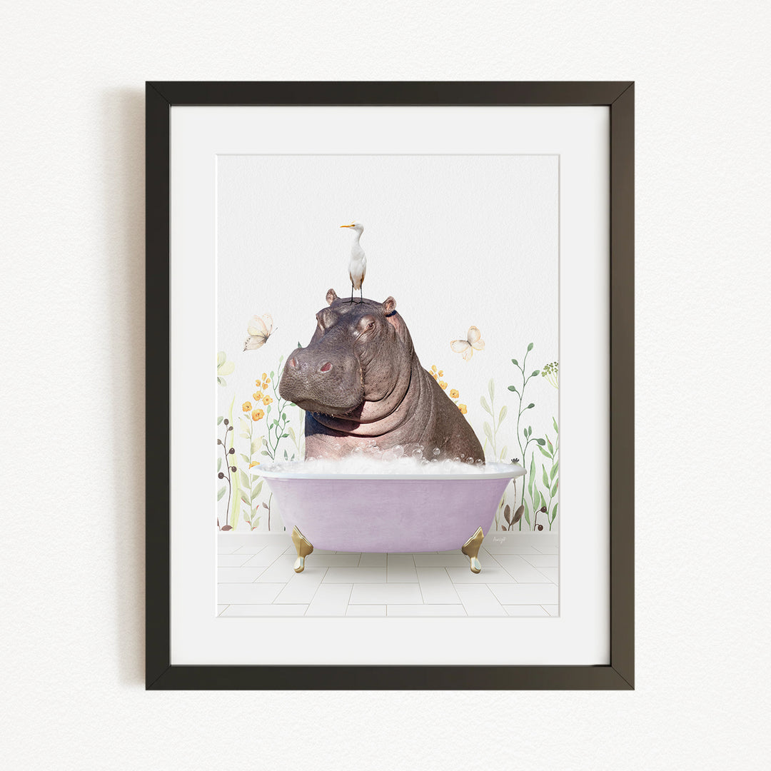 A framed image depicting a hippopotamus sitting in a bathtub, with a bird perched on its head.