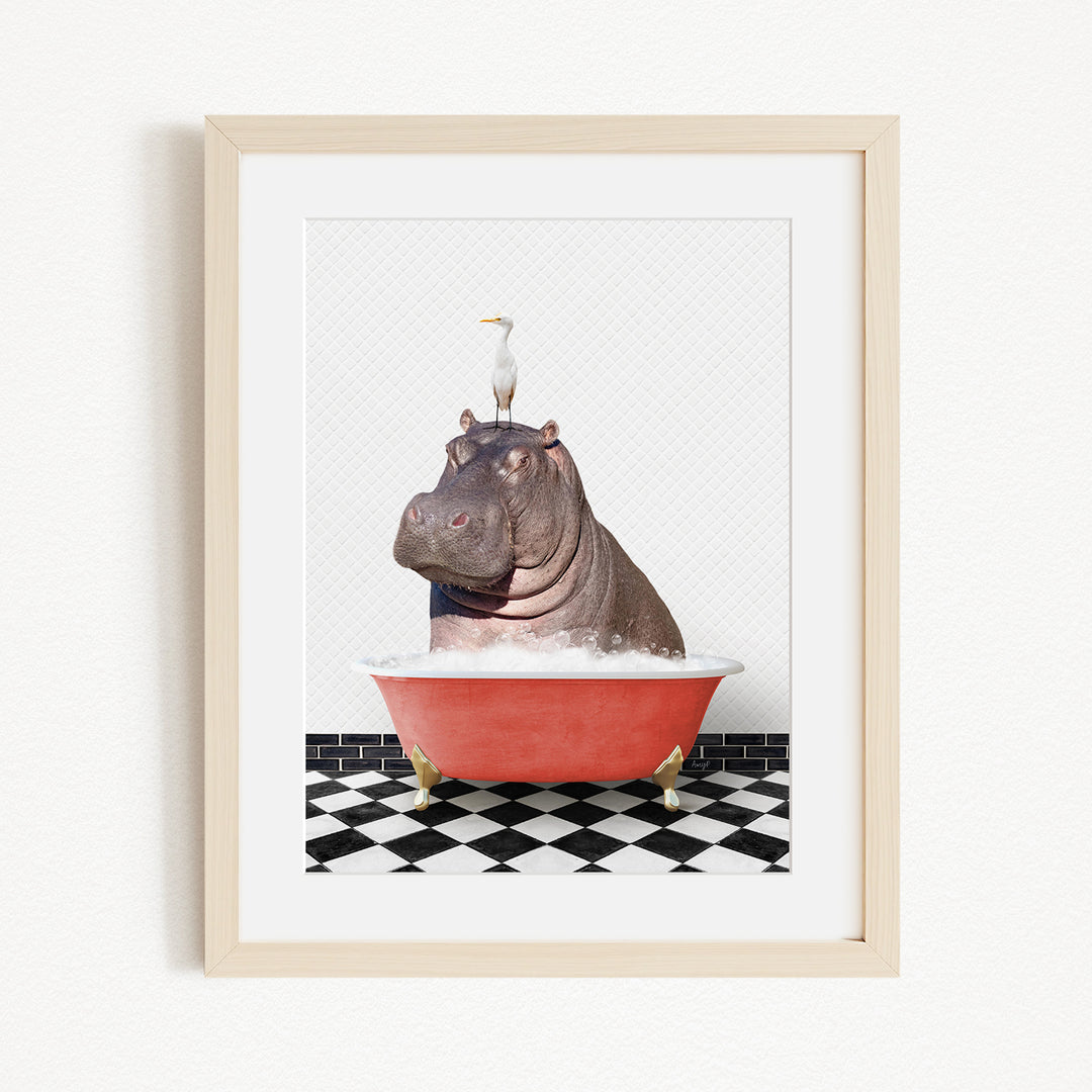 A framed image depicting a large hippopotamus sitting in a red bathtub, with a seagull perched on its head.