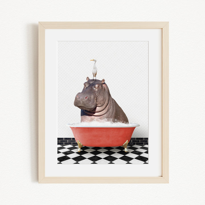 A framed image depicting a large hippopotamus sitting in a red bathtub, with a seagull perched on its head.