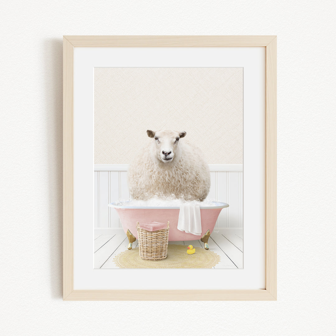 A fluffy white sheep sits in a pink bathtub, surrounded by a yellow rubber duck and a basket.