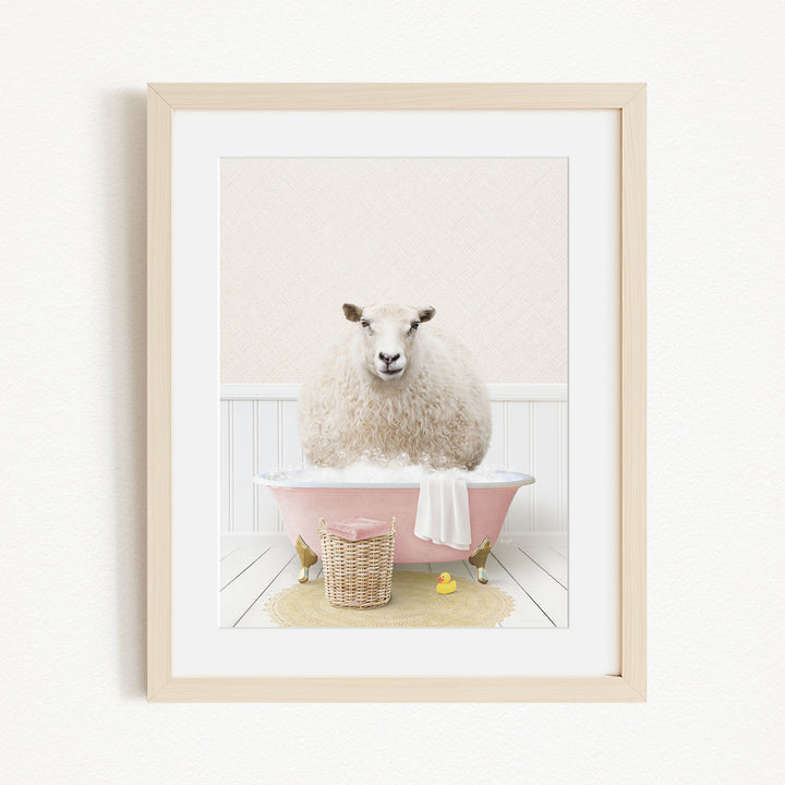 A fluffy white sheep sits in a pink bathtub, surrounded by a yellow rubber duck and a basket.