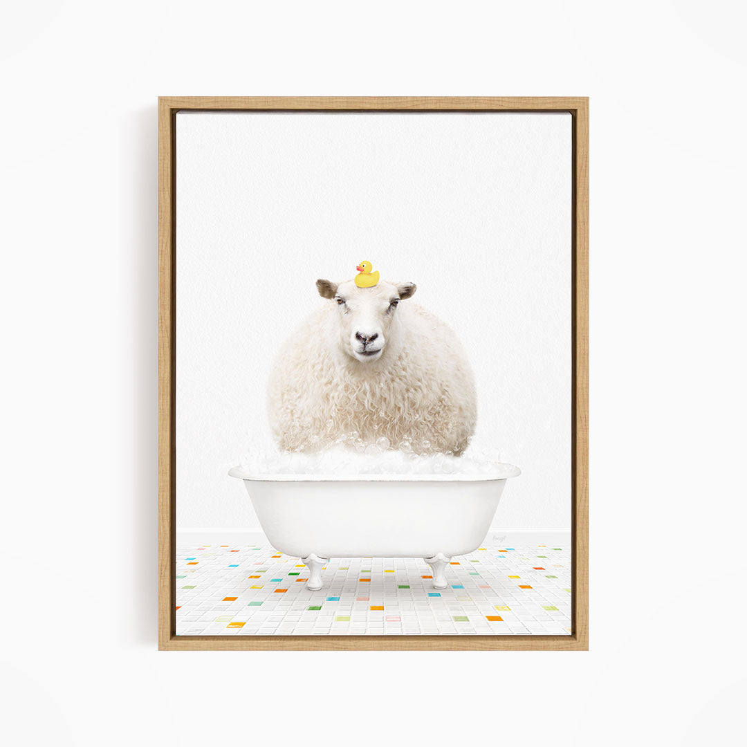 A fluffy white sheep sits in a white bathtub filled with bubbles, with a yellow rubber duck perched on its head.