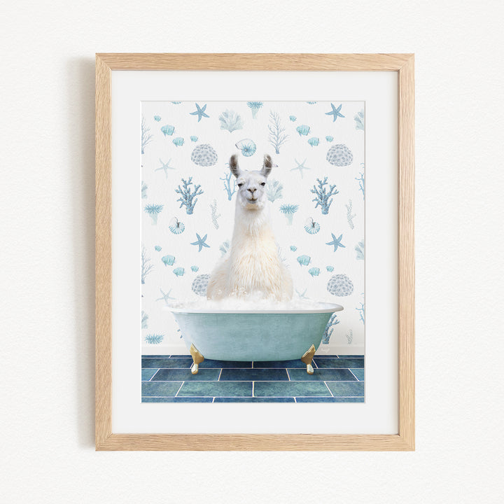 A white llama sitting in a blue bathtub filled with bubbles, surrounded by a pattern of blue and white seashells and starfish.