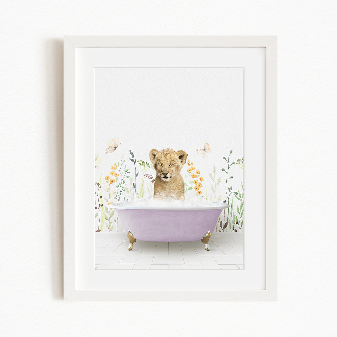 A young lion cub sitting in a purple bathtub filled with bubbles, surrounded by a floral background.